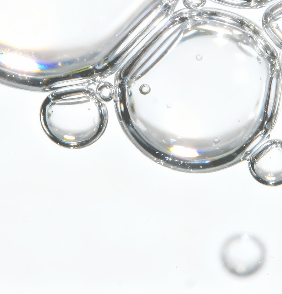 Macro view of clear serum droplets representing hyaluronic acid and betaine in COSRX Advanced Snail 92 All In One Cream; formula provides long-lasting hydration and plump smoothness, enhancing the skin’s firmness and radiance over time.