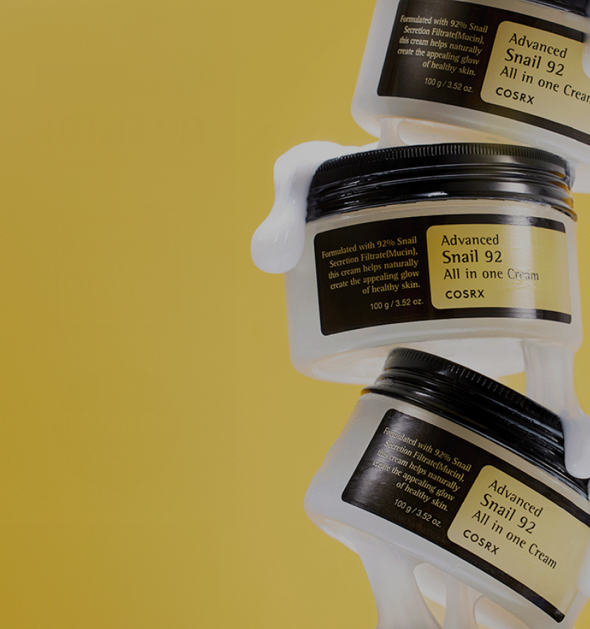 Stack of COSRX Advanced Snail 92 All In One Cream jars on yellow background with text ‘No.1 Global Cream’; daily recovery moisturizer formulated with 92% snail mucin to hydrate, repair barrier, and boost elasticity for luminous, glass-like skin. Global K-beauty favorite for anti-aging hydration care.